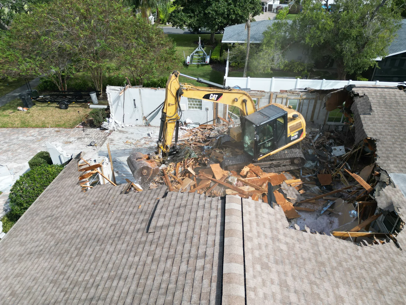 Roof coming down in sections as the excavator works through the structure